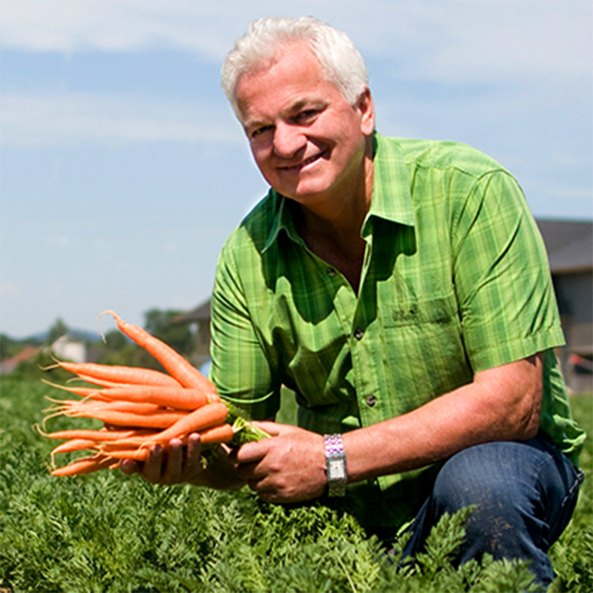 Günter Achleitner from Bio Gemüse KG holding carrots in a field